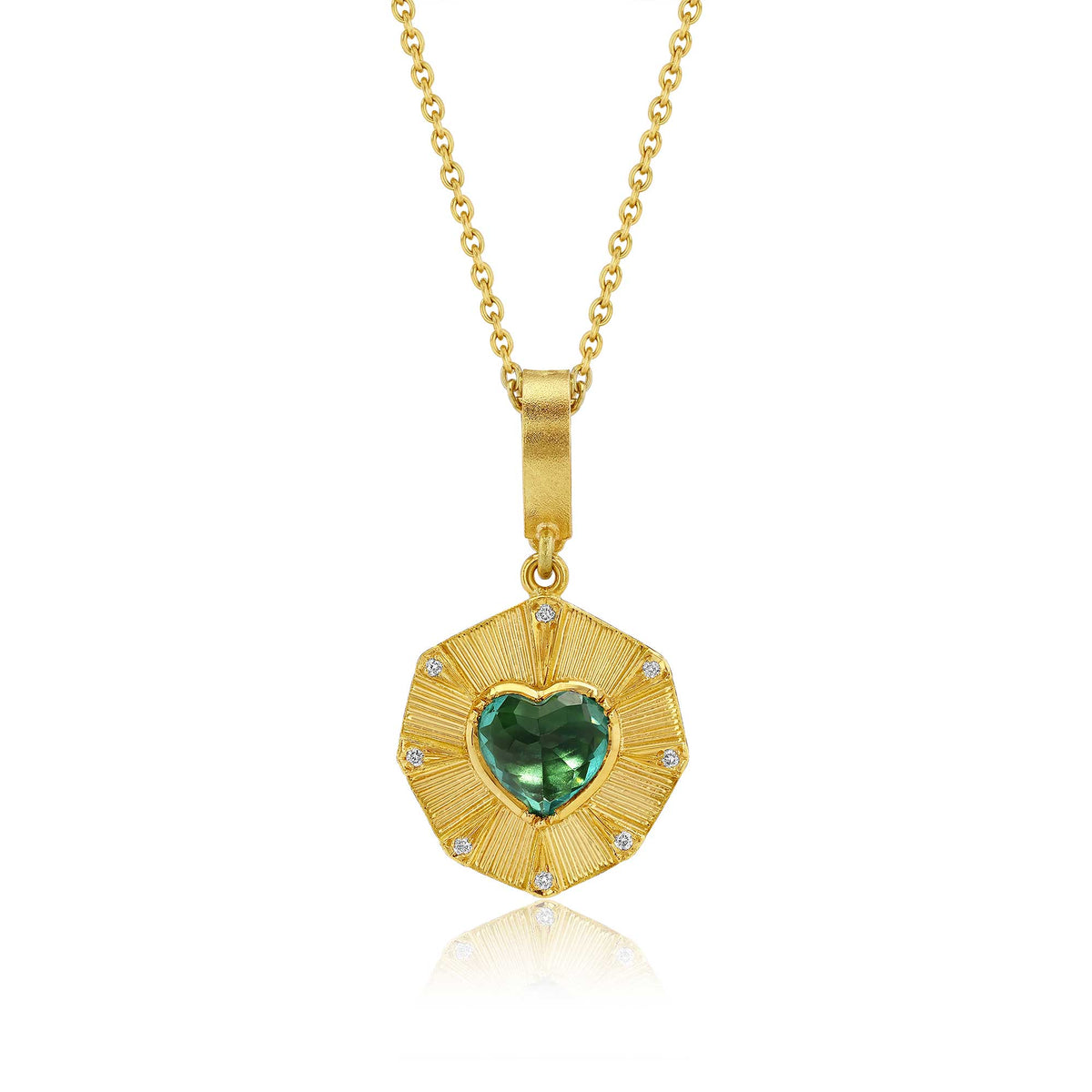 A gold-toned 18k necklace charm featuring a pendant with a vibrant blue-green tourmaline heart motif, with hand engraved rays and white diamond accents. This charm is on a simple round chain and is displayed against a solid white background.