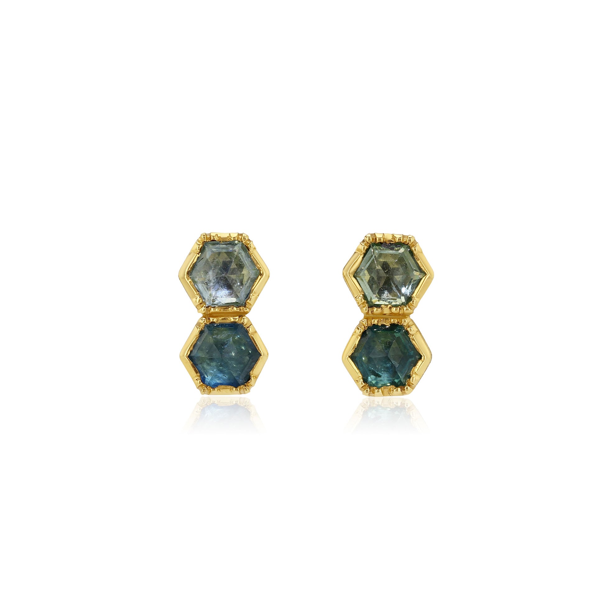 Pair of hexagonal blue sapphire gemstone earrings with gold accents on a white background