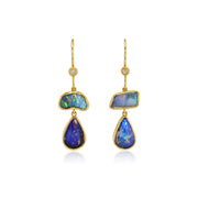 A pair of gold drop earrings featuring irregular blue opal stones and teardrop-shaped blue opal drops, each accented with a small clear stone near the hook, shown on a white background.