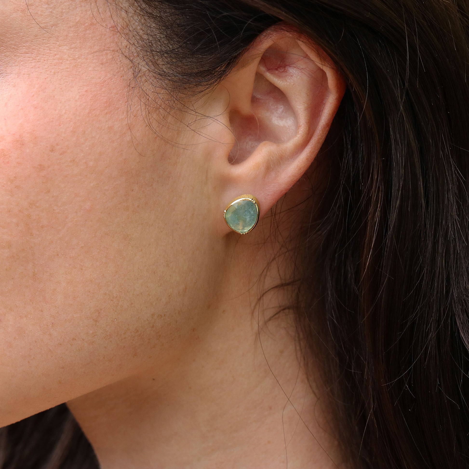 Close up of girl wearing aquamarine stud earrings with 18k gold designed by Brooke Gregson.
