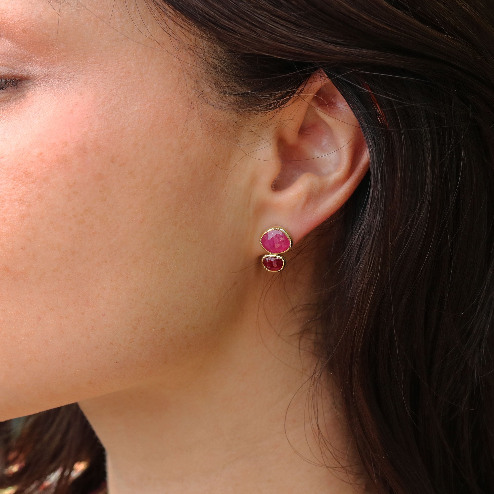 Girl wearing stud earrings with two pink sapphires and 18k gold stud closures by Brooke Gregson.