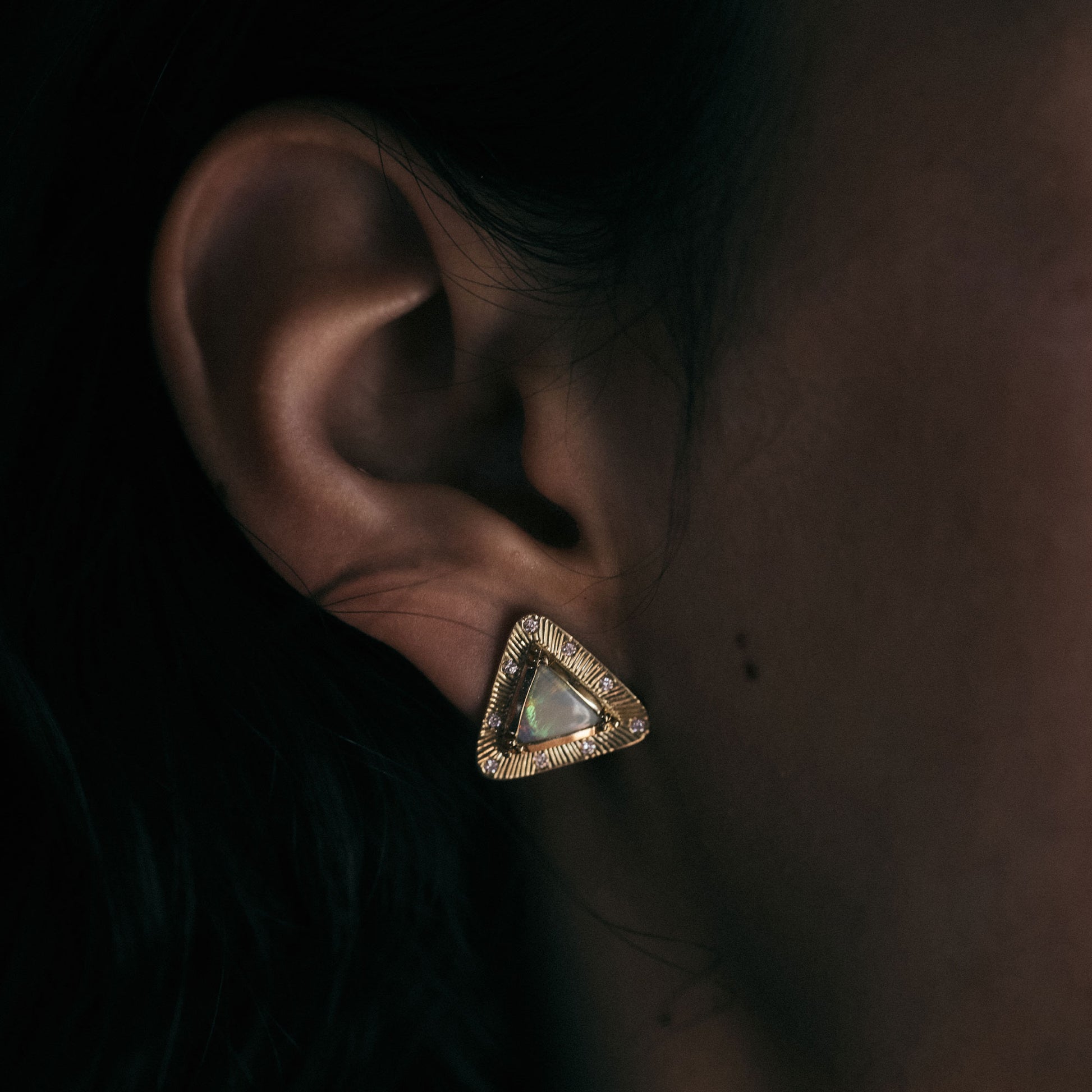 close up of earring opal and hand engraved gold