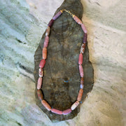 Necklace with multicolored beads on a stone surface