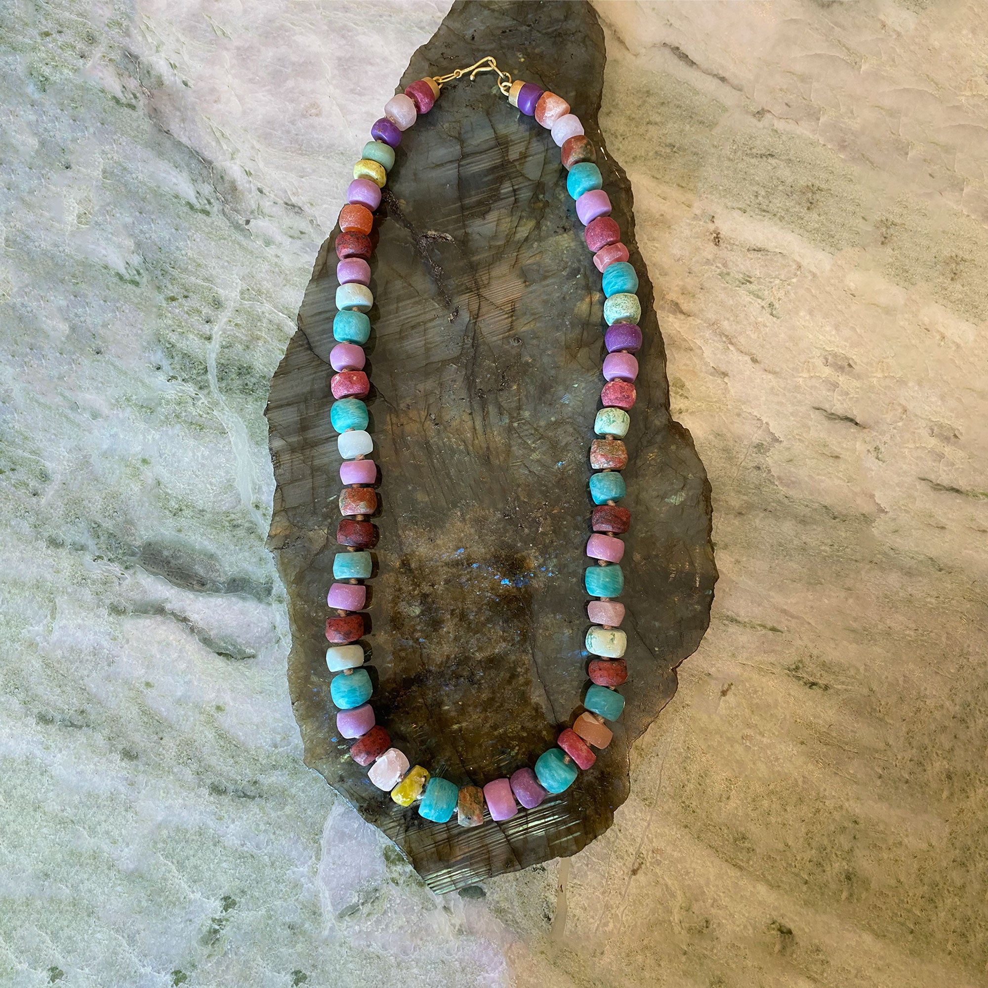 Colorful beaded necklace on a large stone surface
