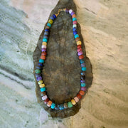 Colorful beaded necklace on a textured stone surface