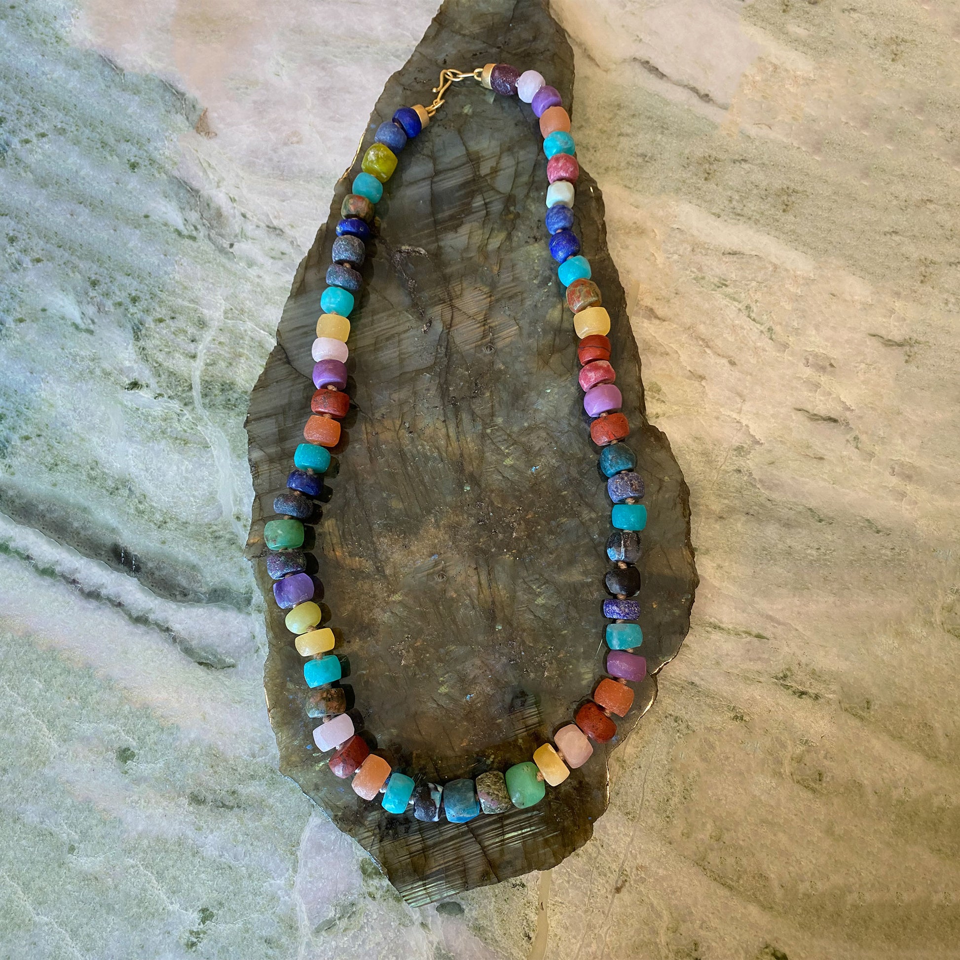 Colorful beaded necklace on a textured stone surface