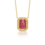 Gold necklace with a red ruby buddah gemstone pendant on a white background