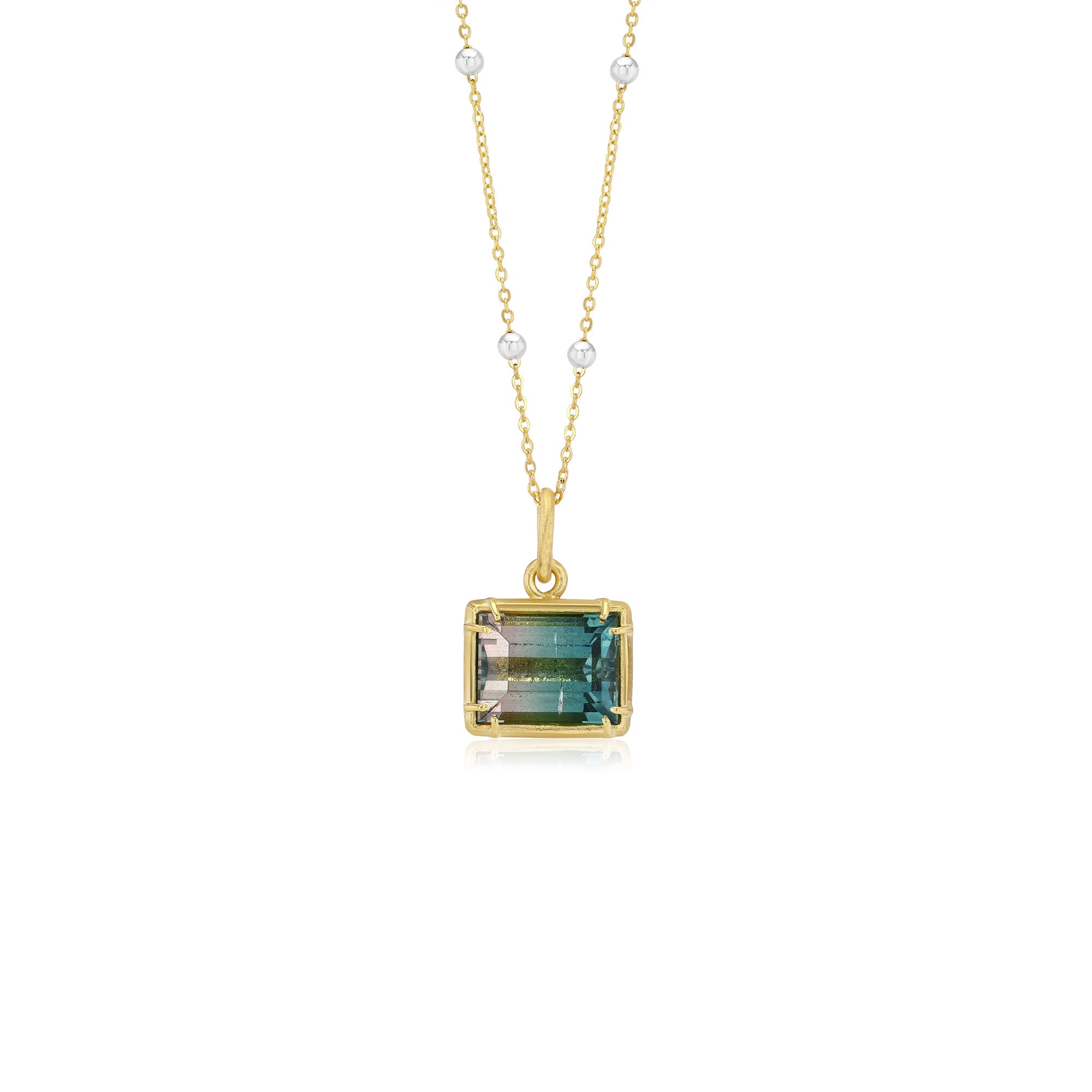 Gold necklace with a bi color tourmaline gemstone pendant on a white background