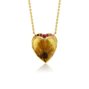 A gold heart-shaped pendant necklace featuring a botanical dendritic agate inside, accented with small pink gemstones along the top curve, shown on a white background with a soft reflection.