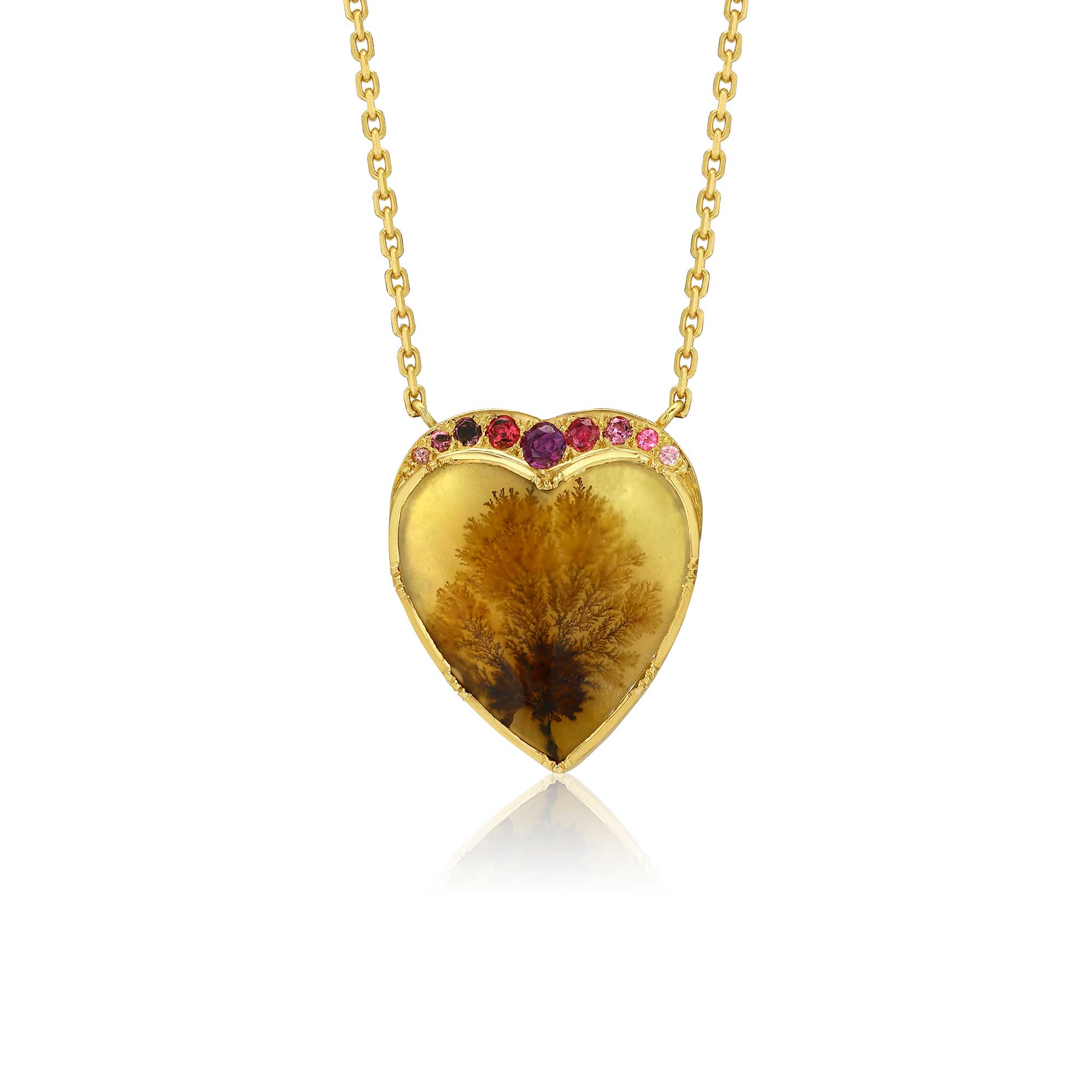 A gold heart-shaped pendant necklace featuring a botanical dendritic agate inside, accented with small pink gemstones along the top curve, shown on a white background with a soft reflection.