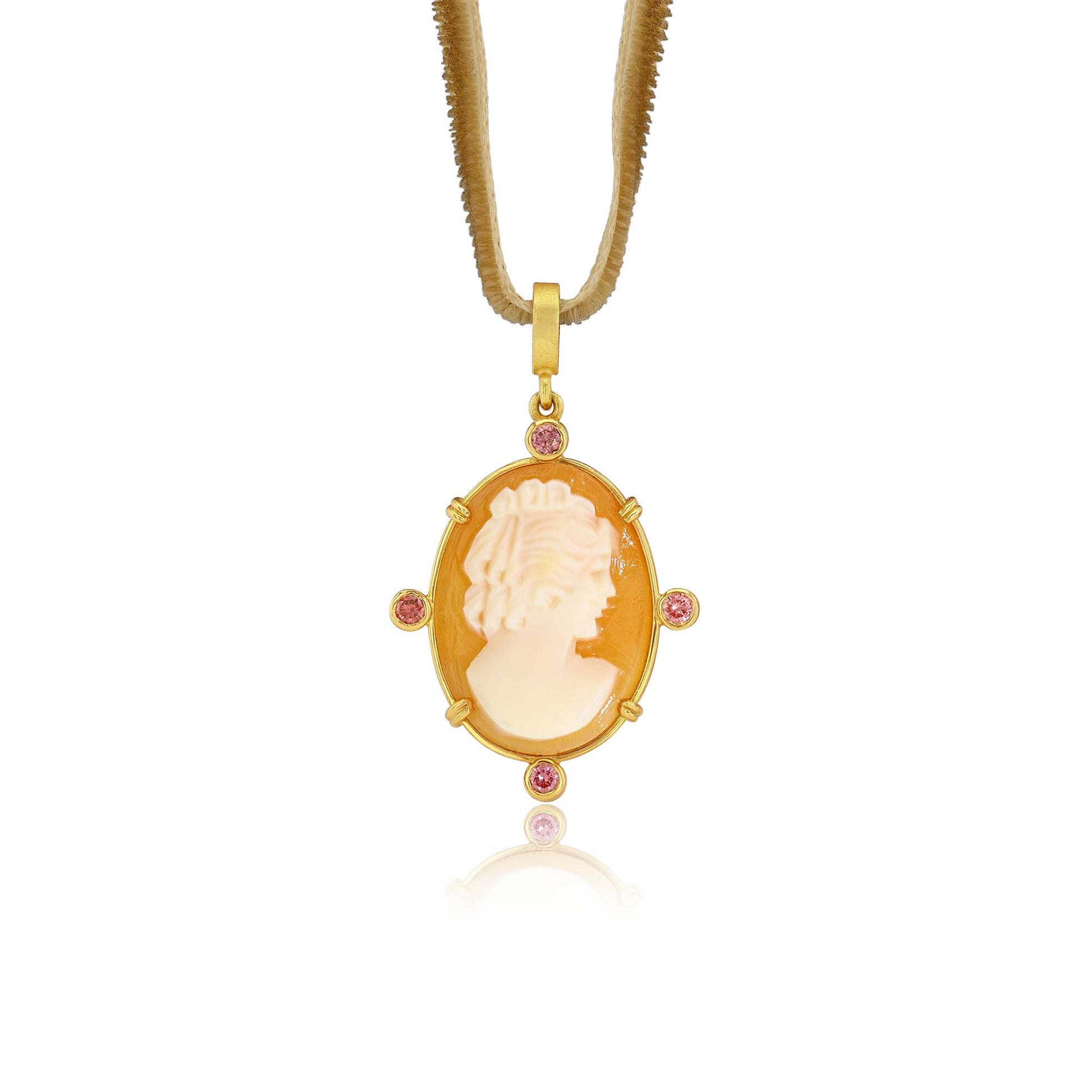 A gold pendant necklace featuring a carved cream-colored cameo-style profile in an oval frame, accented with four small pink tourmaline gemstones, suspended from a gold chain on a white background.