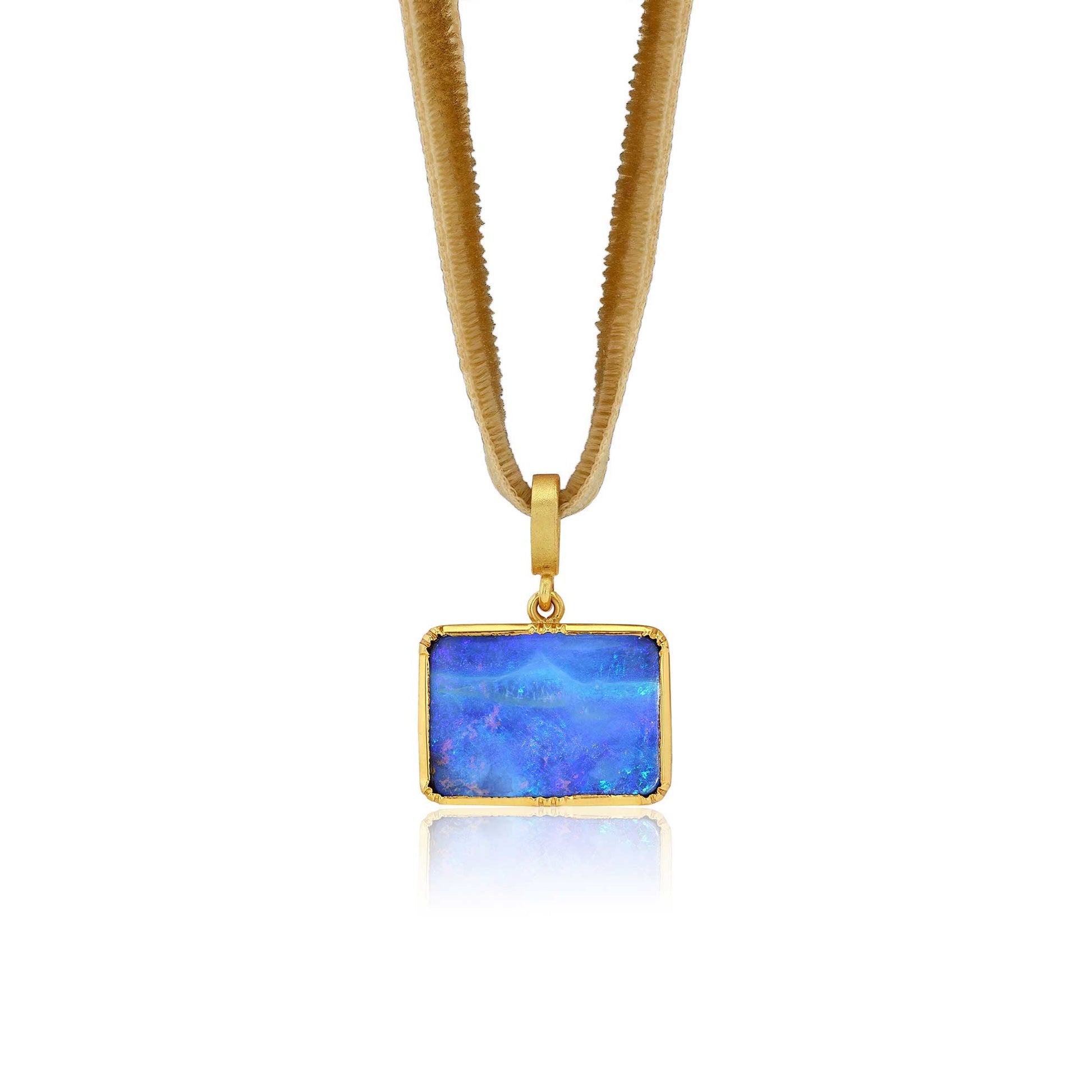 A gold pendant necklace featuring a rectangular blue opal stone with vibrant iridescent play-of-color, suspended from a textured gold snake chain against a white background.