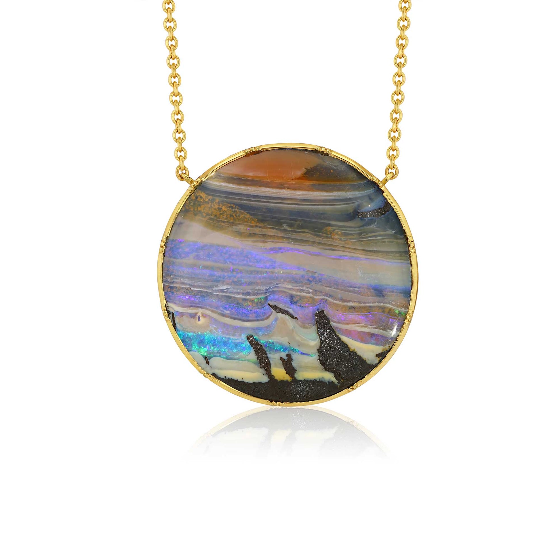 A gold chain necklace with a round bezel-set pendant featuring a colorful opal inlay with shades of purple, blue, orange, and black, displayed on a clean white background with a soft reflection.