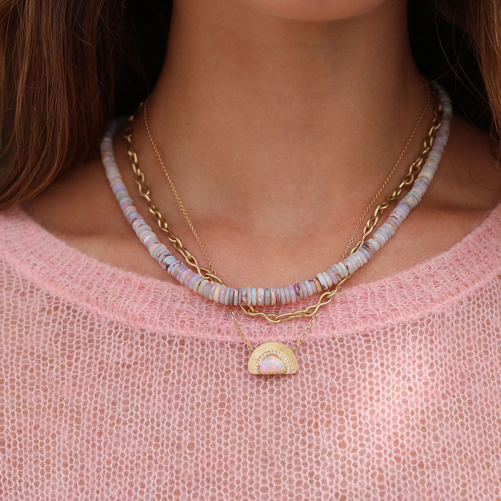 Model wearing one of a kind 18k gold necklace with an opal sun ray design, featuring hand engraving and white diamond pave from Los Angeles jewelry designer Brooke Gregson