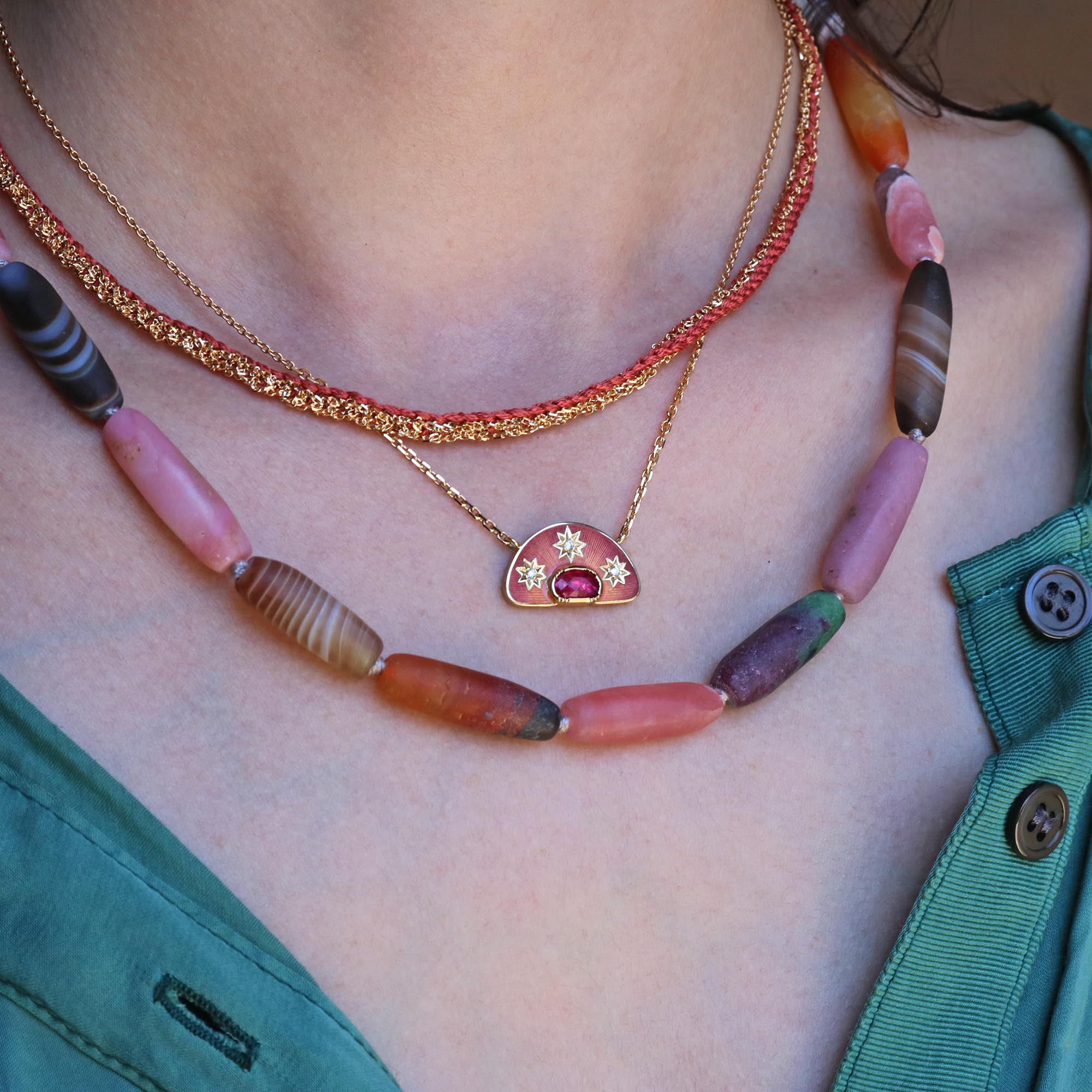 Model wearing one of a kind 18k gold Ruby necklace with star-shaped diamonds and enamel from Los Angeles designer Brooke Gregson handmade in London