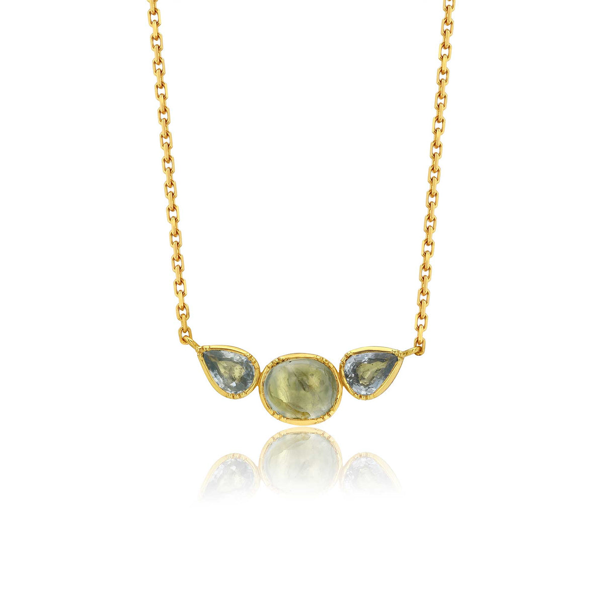 A gold chain necklace featuring a pendant with three teardrop-shaped light blue-green sappphire gemstones in a gold bezel setting, displayed against a white background with a soft reflection below.
