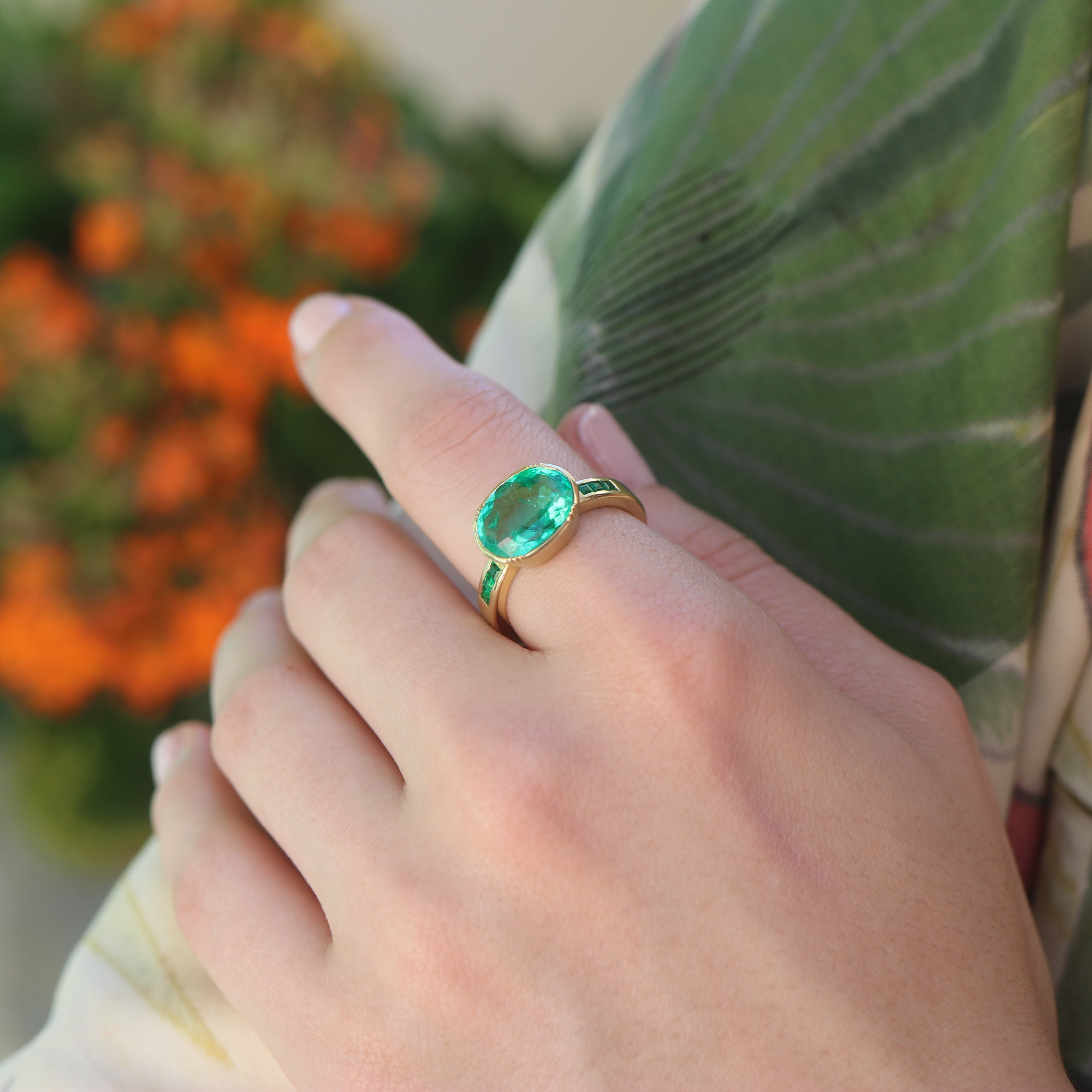 Model wearing one of a kind 18k gold ring with large emerald centre and emerald band detail from Los Angeles jewelry designer Brooke Gregson