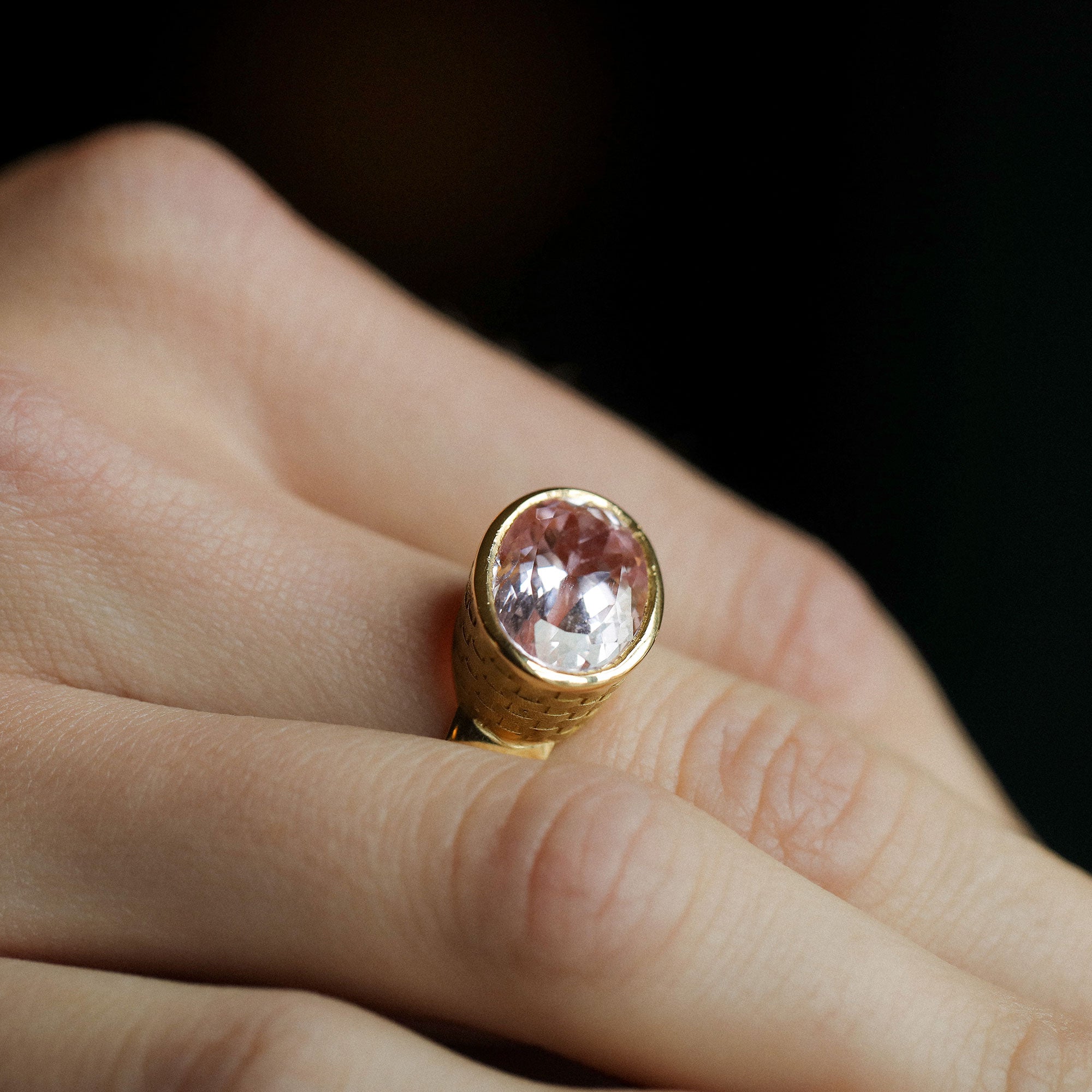 Close up of model wearing one of a kind 18k gold kunzite ring with basket weave engraved setting and brushed gold band from Los Angeles jewelry designer Brooke Gregson