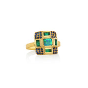 18k gold ring with a center opal, emerald accent stones and sapphire pave on a white background by Brooke Gregson.