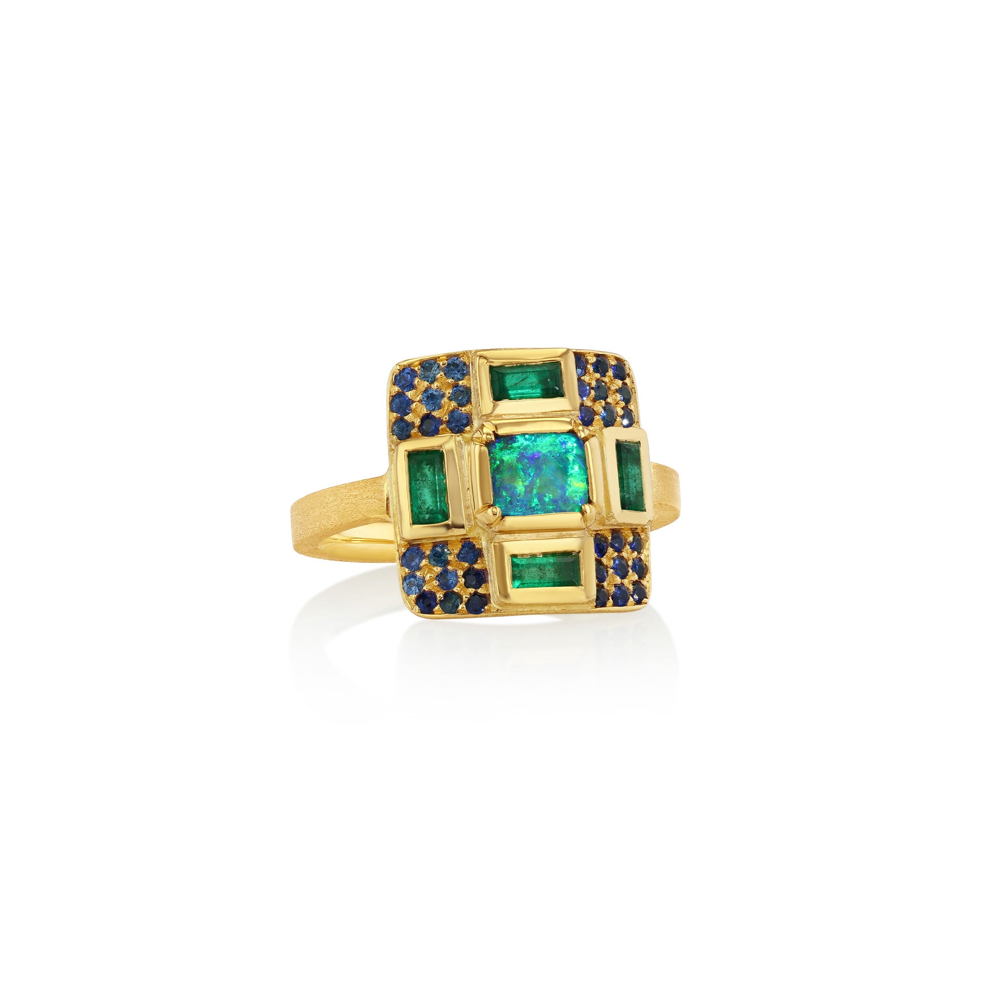 18k gold ring with a center opal, emerald accent stones and sapphire pave on a white background by Brooke Gregson.