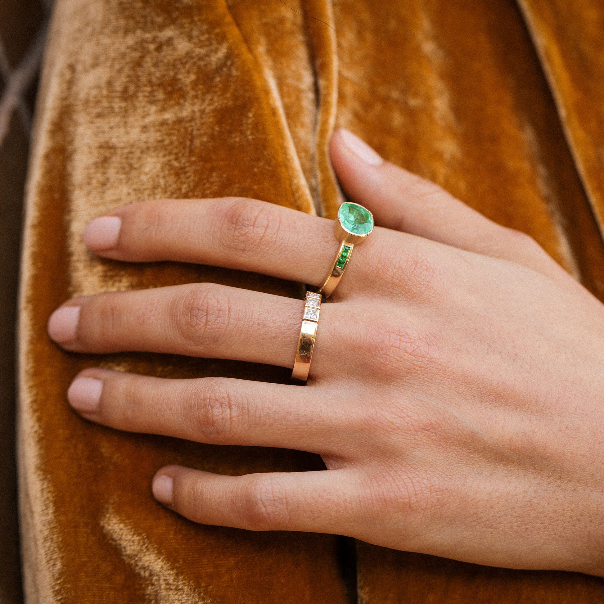 hand wearing a emerald ring with pave emerald in 18k gold by brooke gregson