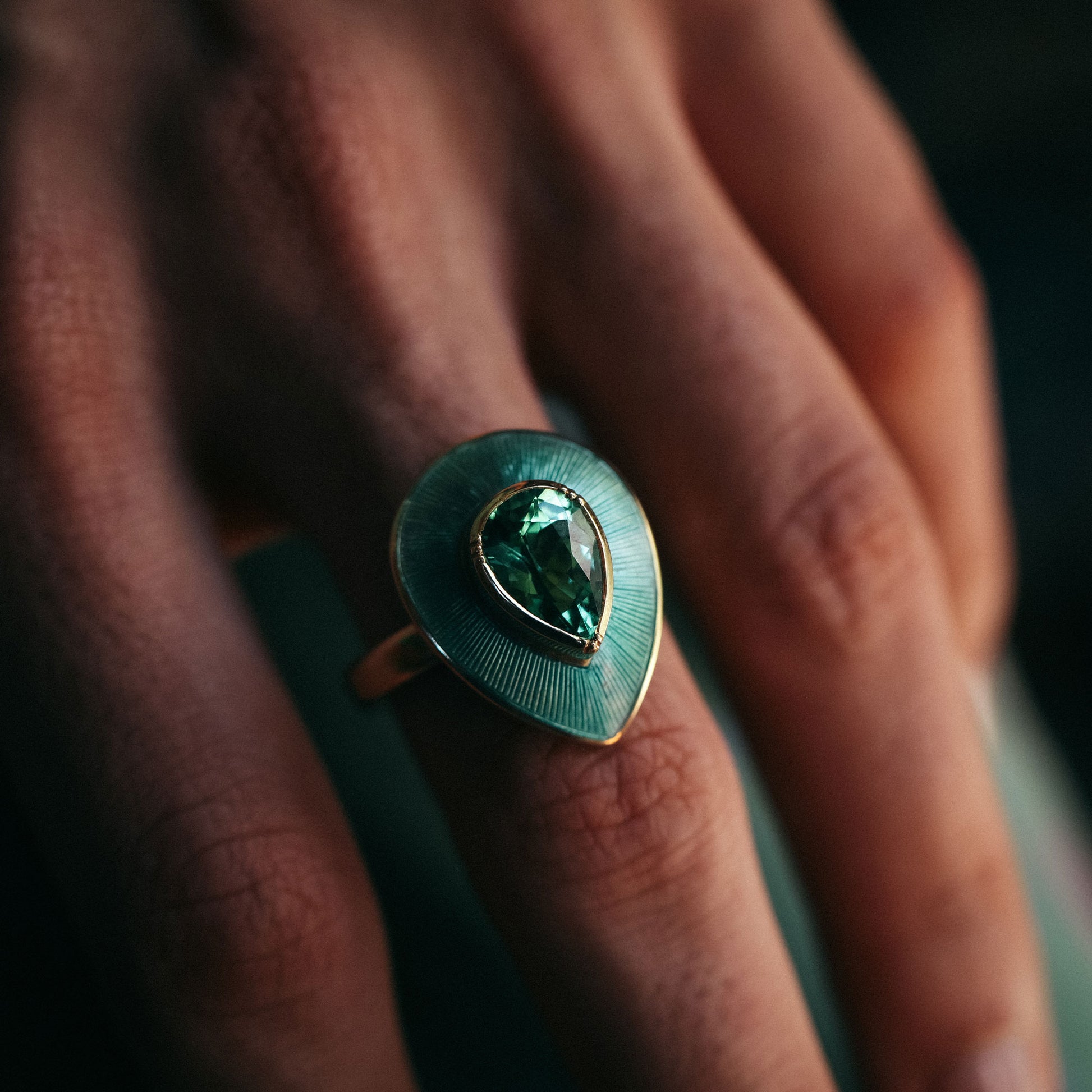 Ring with a green gemstone on a person's finger