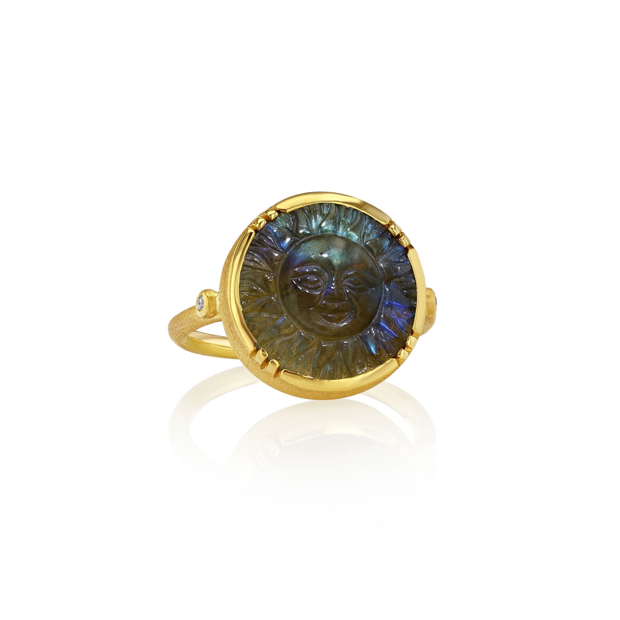 Gold ring with a carved labradorite face design on a white background