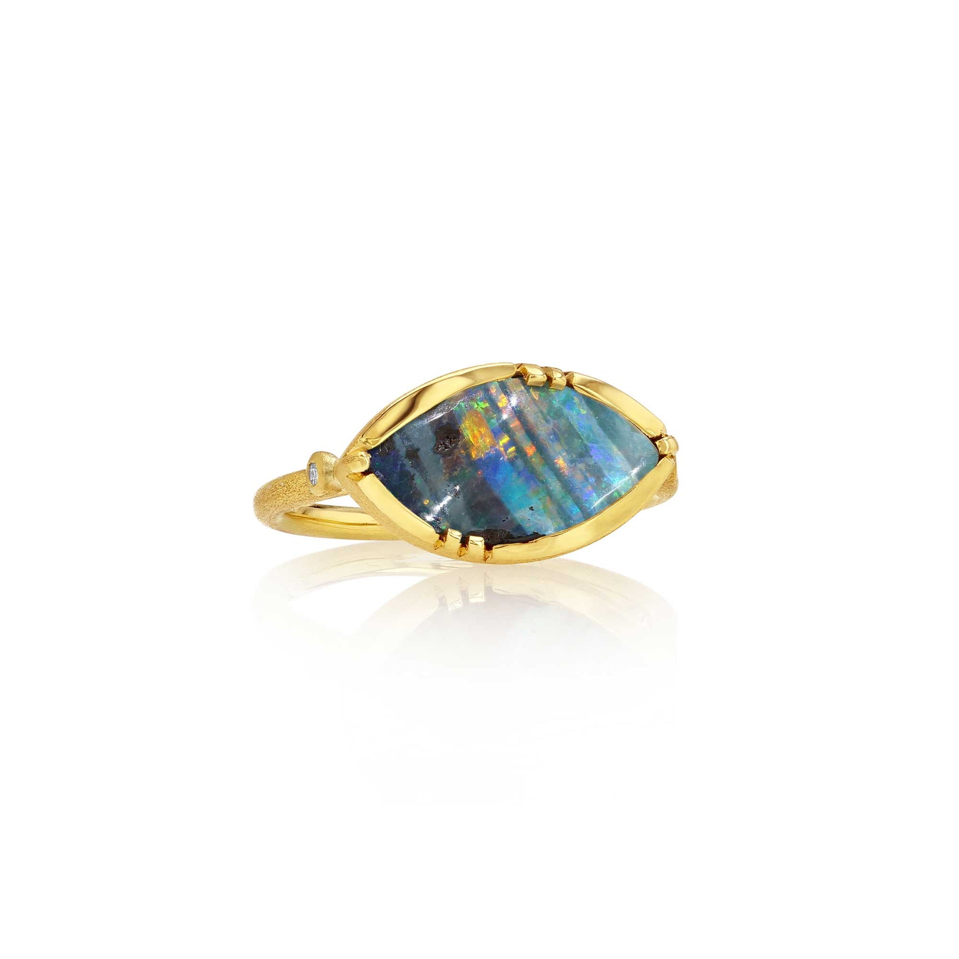 A gold ring featuring a marquise-shaped iridescent boulder opal stone with blue, green, and orange flashes, set in a gold bezel on a white background with a soft reflection.