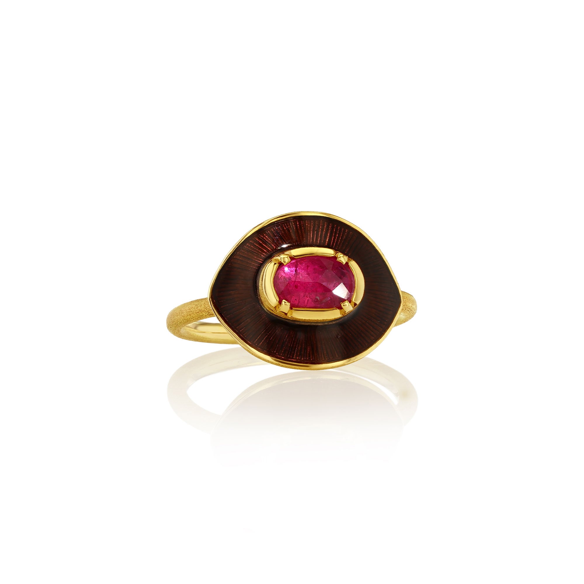 A gold ring featuring a large, scalloped dark reddish-brown enamel inlay and a central oval pink ruby gemstone, shown on a clean white background with a soft reflection.