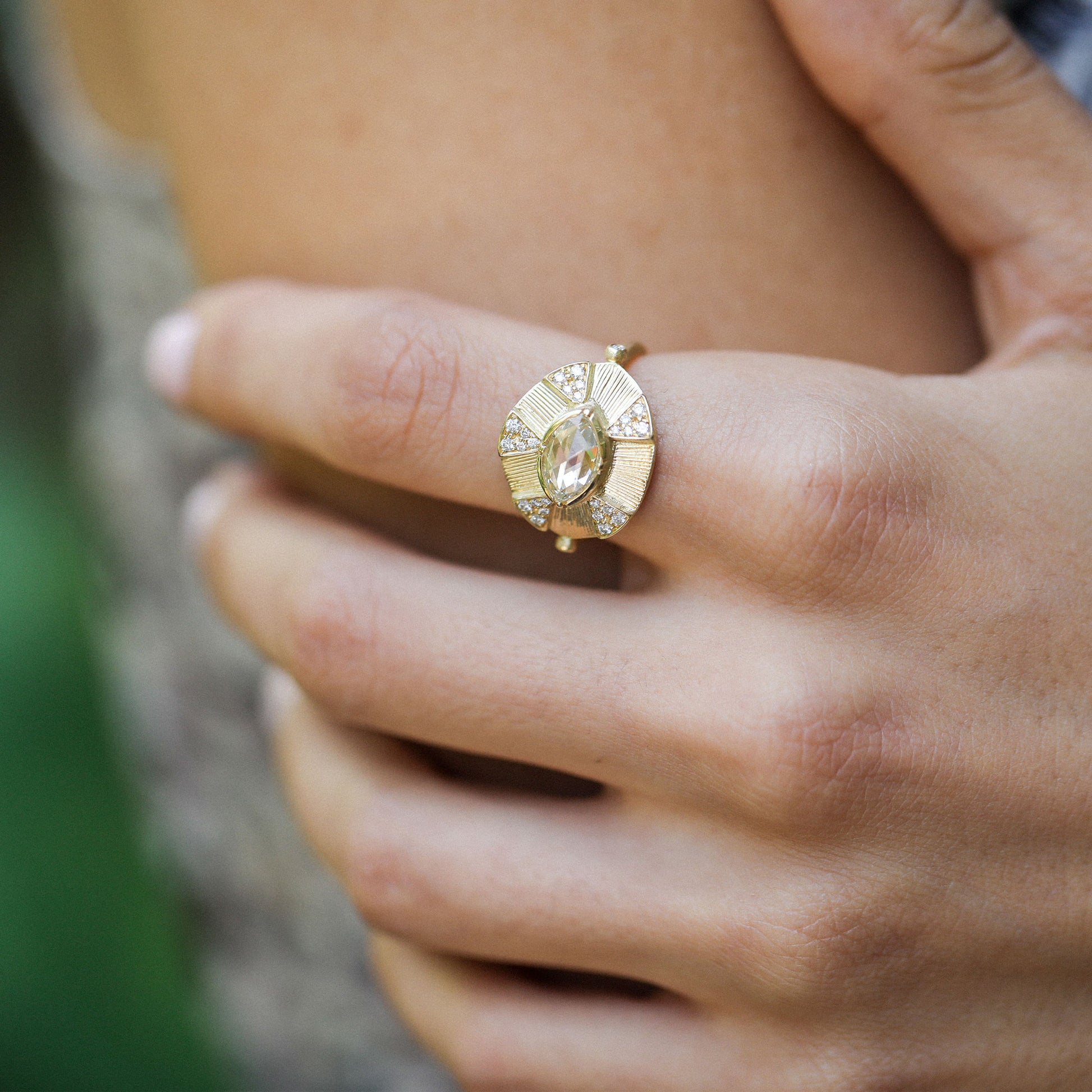 close up of a girl wearing an 18k gold ring with white diamonds and hand engraving by brooke gregson jewelry designer